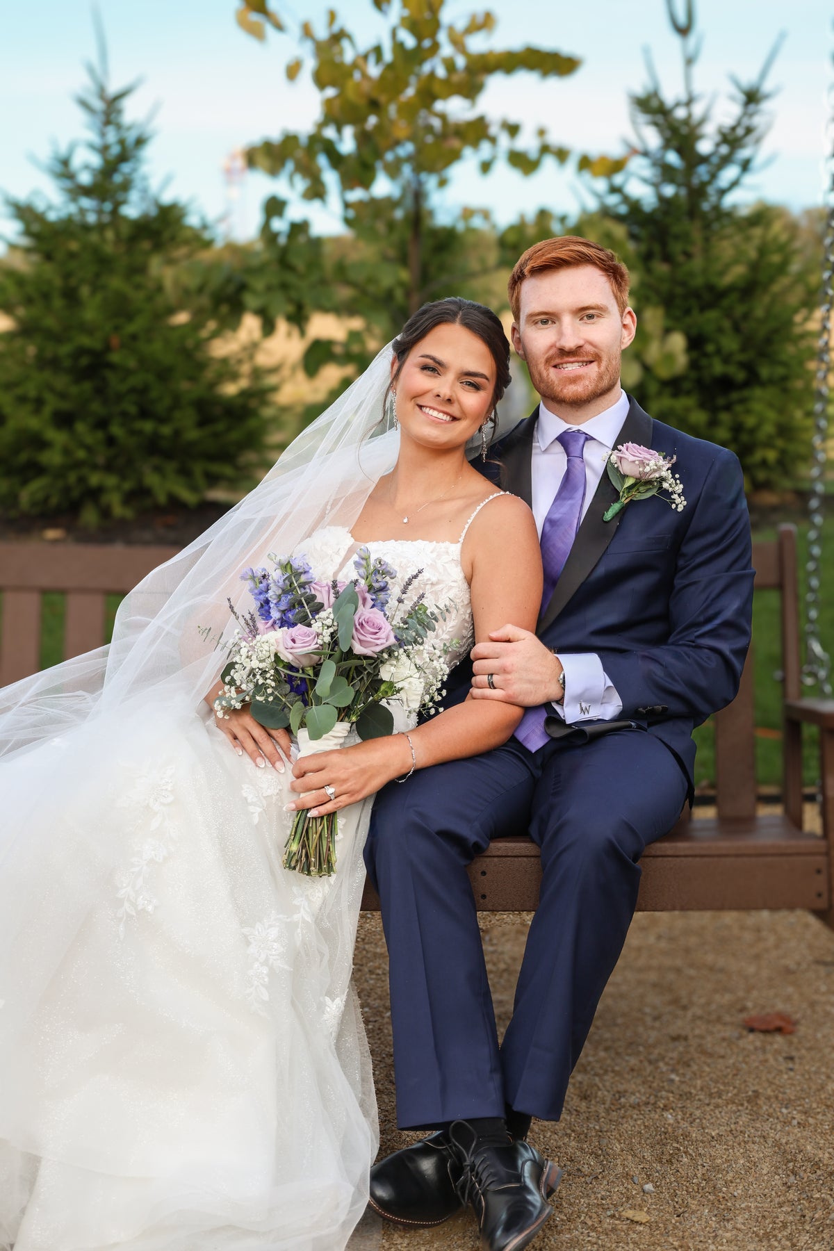Amy and Jarrett seated together with her bridal bouquet.