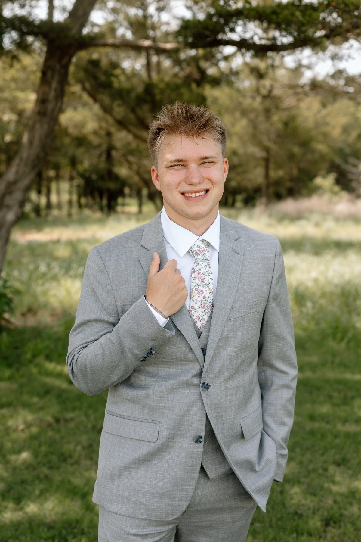 Ryan smiling outdoors in his gray suit and tie.