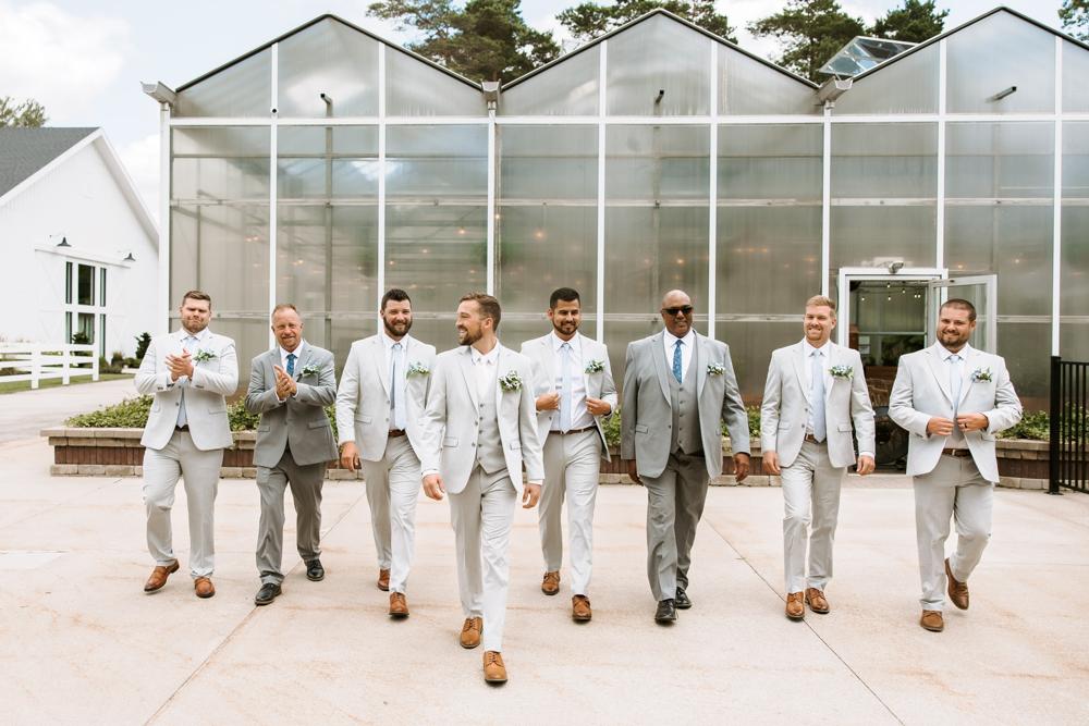 Men in suits standing in front of a greenhouse