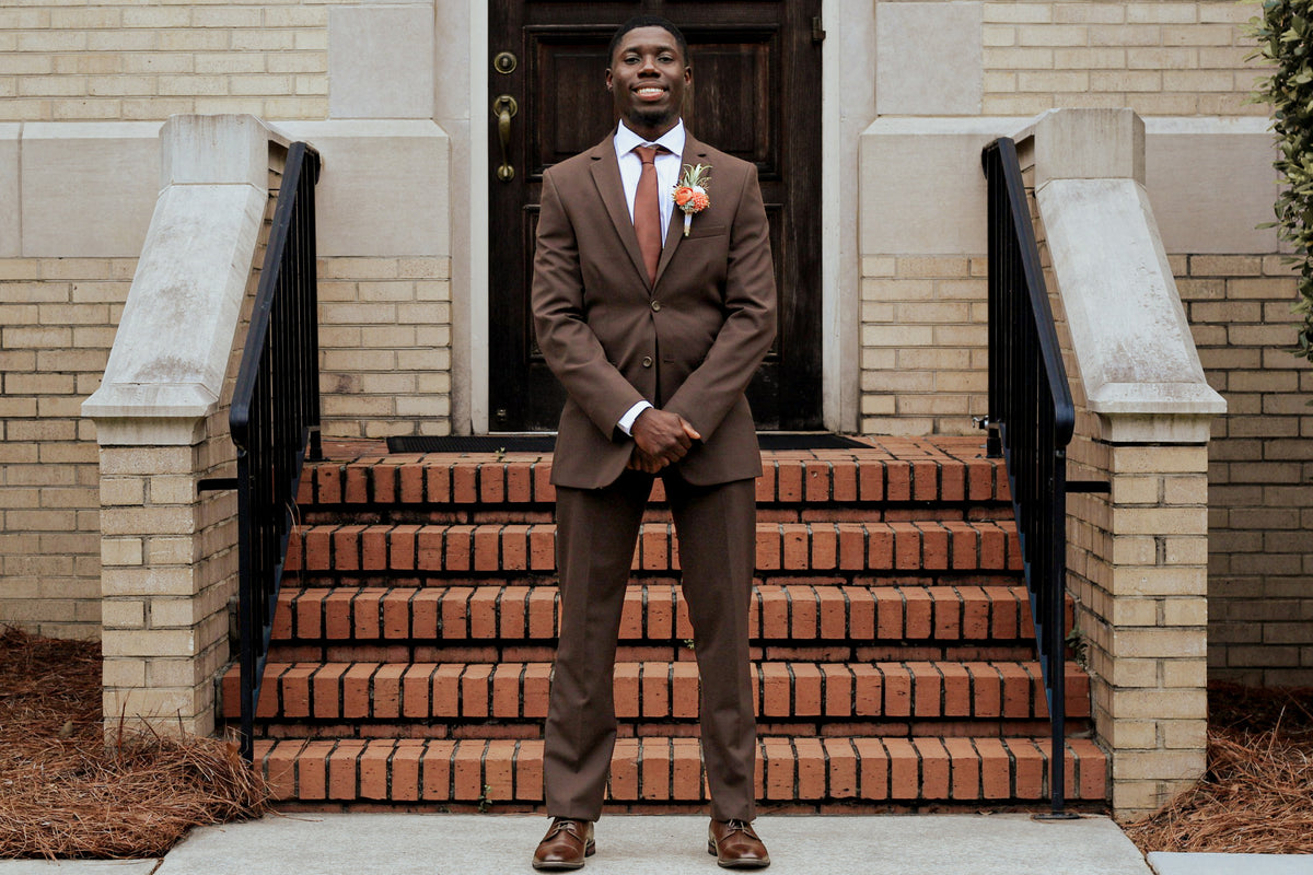 Dontavious posing on brick steps in his chocolate suit.