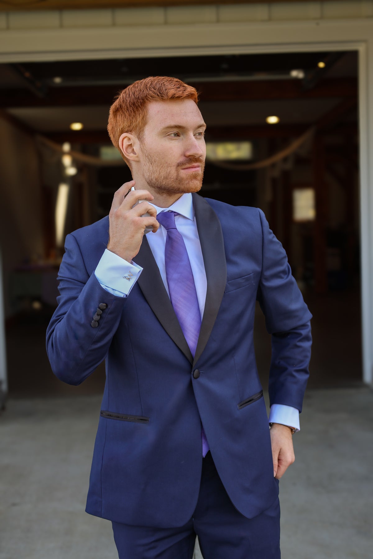 Jarrett adjusting his navy tuxedo and purple tie.
