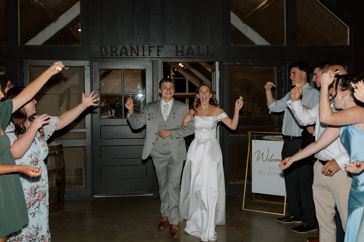 Ava and Ryan entering their wedding reception through wooden barn doors.