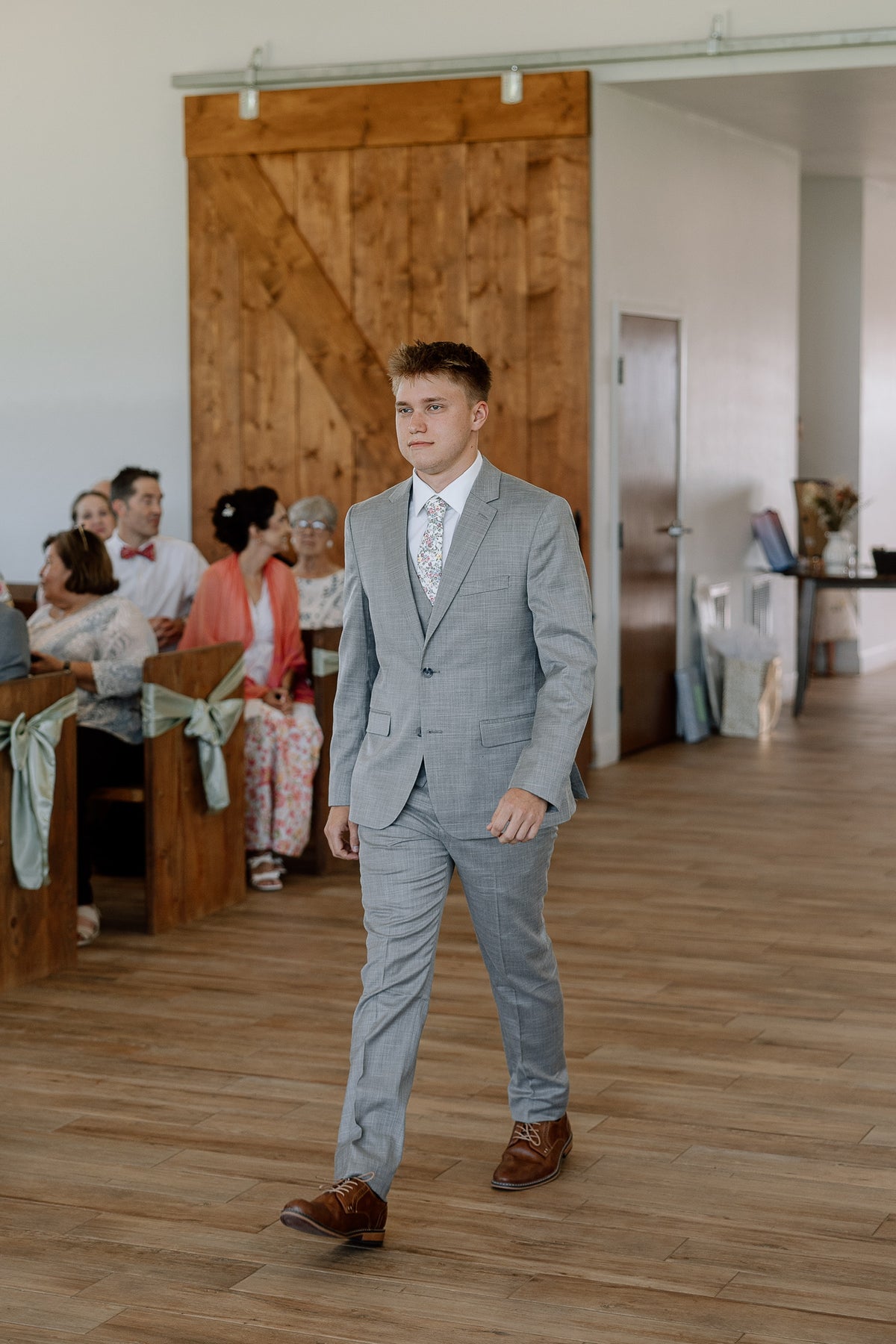 Ryan walking down the aisle in his gray suit.
