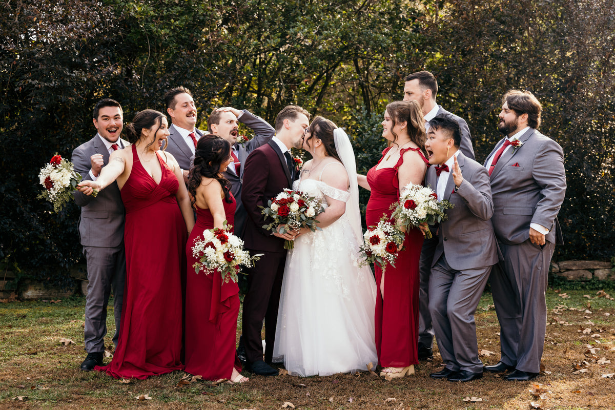Diana and Nicolas celebrating with their wedding party outdoors.