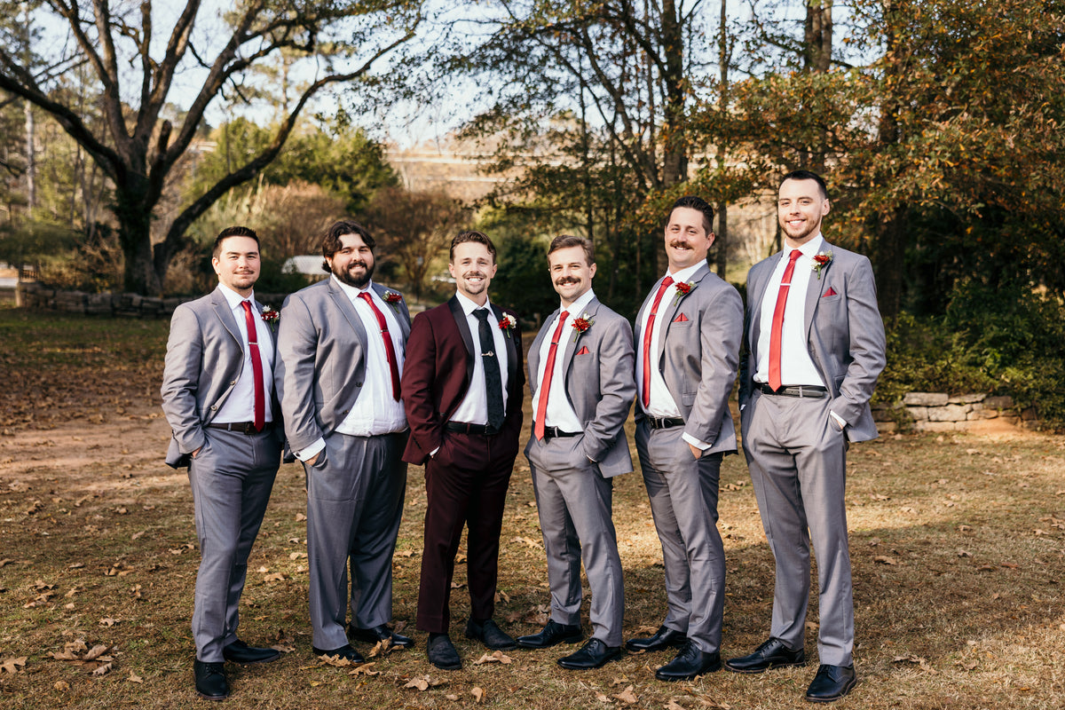 Nicolas and his groomsmen posing together outdoors.