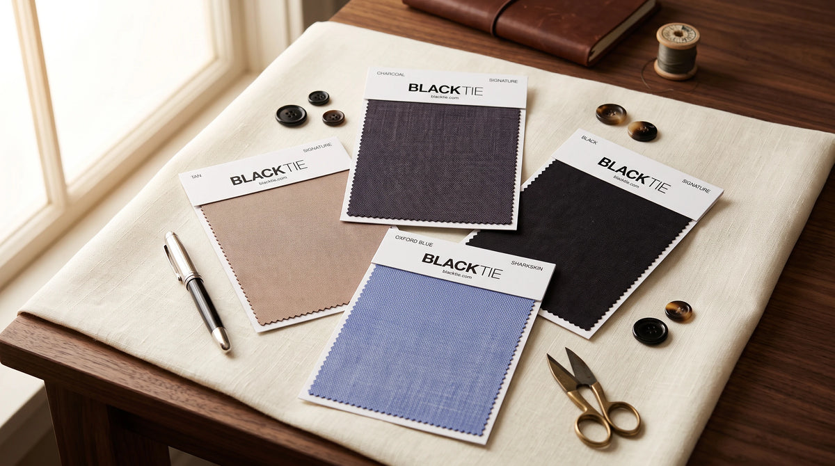 Four fabric color swatch cards labeled BLACK Tie are arranged on a cream cloth over a wooden table, with sewing notions like buttons, scissors, a pen, and a spool nearby.