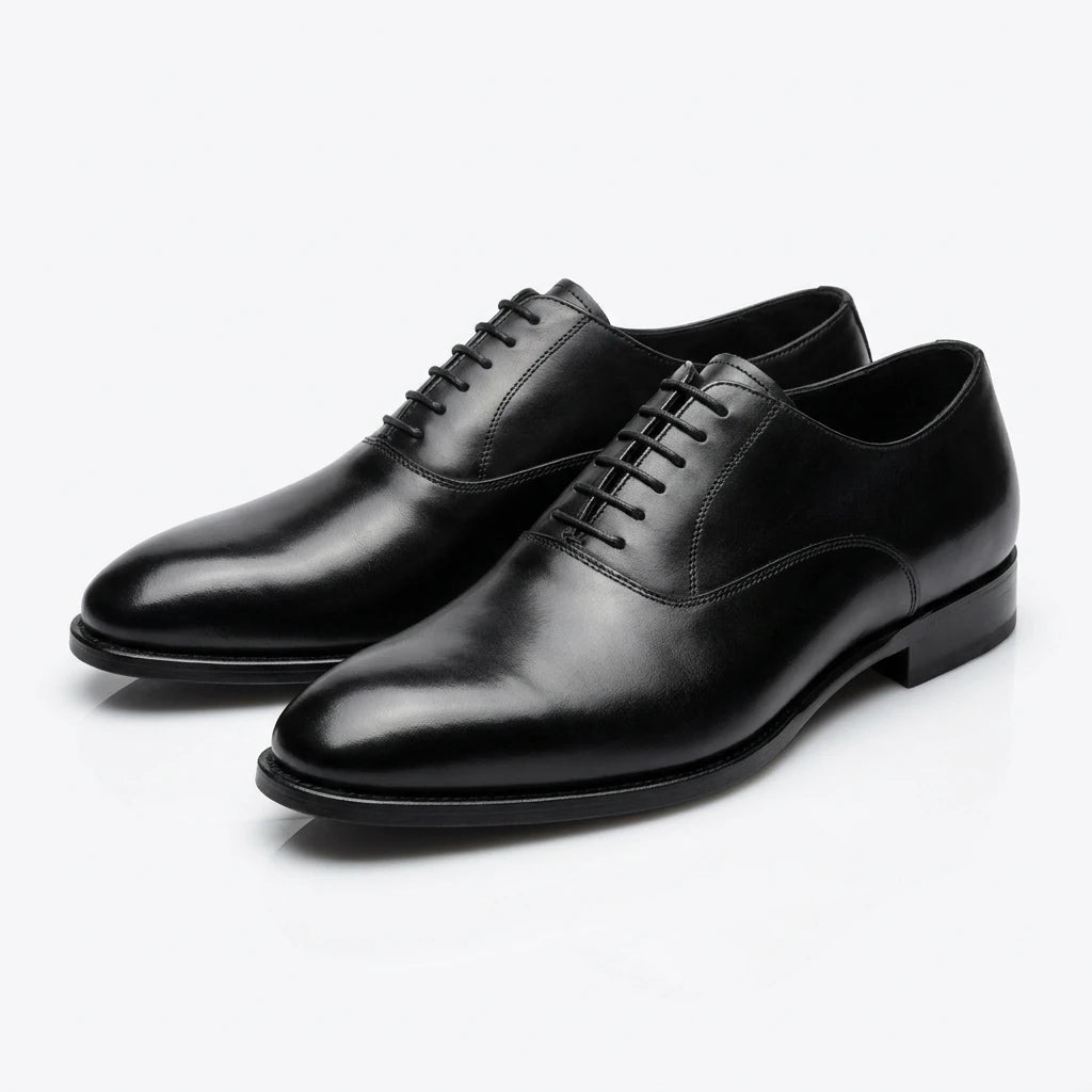 Pair of black leather dress shoes on a white background